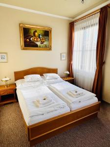 a bedroom with a large bed with a painting on the wall at Penzion Villa Ancora in Šumperk