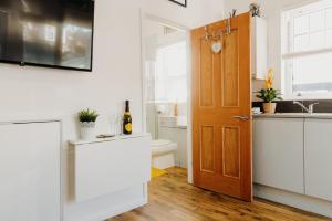 a kitchen with a door and a sink and a toilet at Superb Tiny Home in Caldicot with Parking in Caldicot