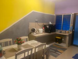 a room with a table and chairs and a kitchen at ANGGUN HOMESTAY Banting in Banting