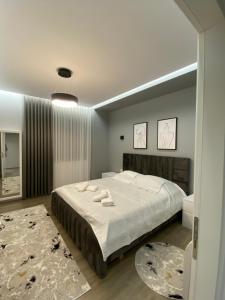 a bedroom with a large bed with white sheets at Riar Apartaments in Korçë