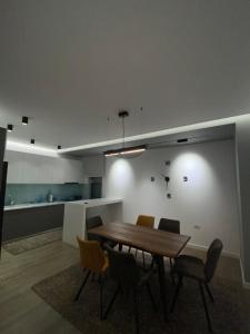 a dining room with a wooden table and chairs at Riar Apartaments in Korçë