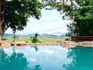 a pool of water with a giraffe in the background at Phu Pha Nam Resort in Dan Sai