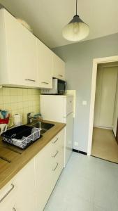 una cucina con mobili bianchi e un lavandino di Beau T2 dans résidence calme 5 Toits et Mois a La Grande-Motte Altre 2 foto
