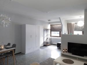 ein weißes Wohnzimmer mit einem TV und einem Tisch in der Unterkunft Huoneisto Ketunpesä in Taivalkoski