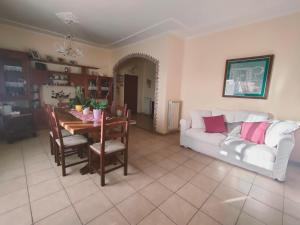 a living room with a table and a white couch at Ros' s house in Corchiano