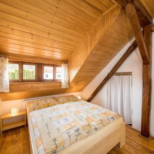 Bett in einem Zimmer mit Holzdecke in der Unterkunft Mlýn Kamenice in Klučenice