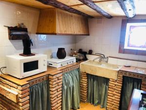 una cucina con forno a microonde e lavandino di Vivienda turística LA CAPE a Segura de la Sierra