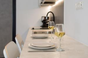 una mesa con dos copas de vino blanco. en Athens Theatrou Apartments, en Atenas