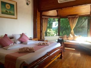 a bedroom with two beds in a room with windows at Phu Pha Nam Resort in Dan Sai
