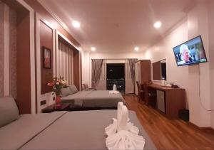 Habitación de hotel con 2 camas y TV de pantalla plana. en 4 RIVERS HOTEL en Phnom Penh