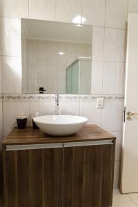 a bathroom with a white sink and a mirror at Casa para 6 pessoas in Bento Gonçalves