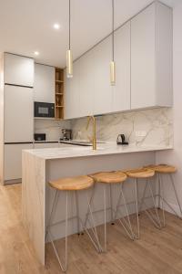 a kitchen with white cabinets and a counter with stools at Premium Apartment LaLatina IV Renovated 4BR 4BH in Madrid