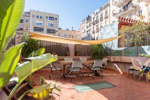 a patio with chairs and a table with a canopy at Eixample8 in Barcelona