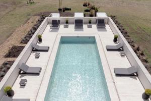 a swimming pool with lounge chairs and a swimming poolvisor at El Salto Suites - Casonas del Haras in Mar del Plata