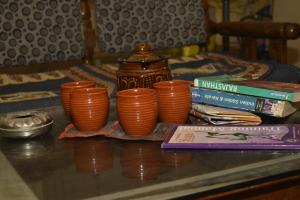 uma mesa com um grupo de copos laranja e livros em Stay Inn Heritage em Varanasi