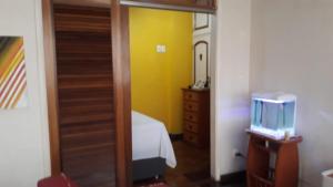 a bedroom with a bed and a yellow wall at Copacabana aconchegante in Rio de Janeiro