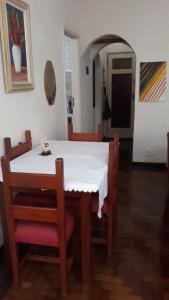 einen Esstisch mit einem weißen Tisch und Stühlen in der Unterkunft Copacabana aconchegante in Rio de Janeiro