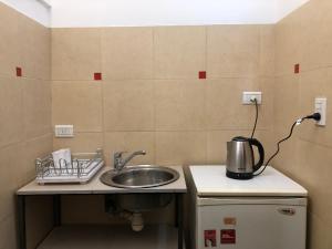 una cocina con fregadero y un hervidor de agua en una encimera en Alojamiento Mitre en Salta