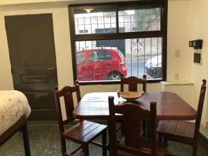 un comedor con una mesa y un coche rojo en una ventana en Alojamiento Mitre en Salta