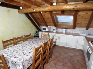 une cuisine avec une table et des chaises dans une pièce dans l'établissement Superbe Duplex 8 Pers. avec Cheminée et Parking Privé à 400m des Pistes, Serre Chevalier - FR-1-762-10, à La Salle Les Alpes