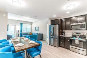 a kitchen and dining room with a table and blue chairs at Apartment at Vista Cay Resort in Orlando