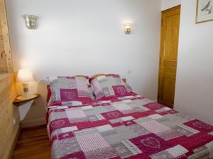 1 dormitorio con 1 cama con edredón rosa y gris en Appartement Saint-Chaffrey , 2 pièces, 4 personnes - FR-1-762-19, en Saint-Chaffrey