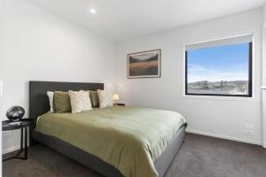 a bedroom with a large bed and a window at Contemporary Urban Retreat in Auckland