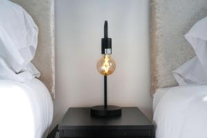 a lamp sitting on a table between two beds at Newly Refurbished House - Close to Town Centre -Free Parking, Super-Fast Wifi, Smart TV with Netflix by Yoko Property in Northampton