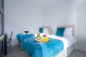 a hotel room with two beds with a tray of fruit at Newly Refurbished House - Close to Town Centre -Free Parking, Super-Fast Wifi, Smart TV with Netflix by Yoko Property in Northampton
