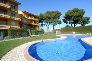 a large swimming pool in front of a building at Apartamentos Athenea in Ampurias