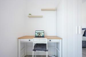 a desk with a laptop on it in a bedroom at Newly Refurbished House - Close to Town Centre -Free Parking, Super-Fast Wifi, Smart TV with Netflix by Yoko Property in Northampton