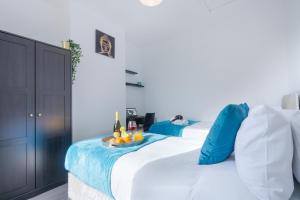 a bedroom with two beds with blue pillows and a tray of fruit at Newly Refurbished House - Close to Town Centre -Free Parking, Super-Fast Wifi, Smart TV with Netflix by Yoko Property in Northampton