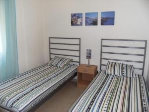 two beds sitting next to each other in a bedroom at Apartamentos Athenea in Ampurias