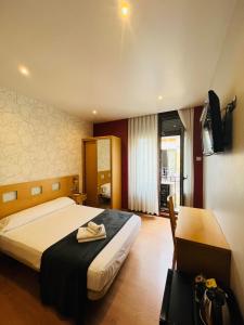 Habitación de hotel con cama y TV en Hostal Abami II, en Madrid