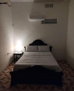 1 dormitorio con 1 cama y mesita de noche con lámpara en SAN SENDERISMO ROOM en Mariquita