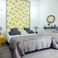 a bedroom with a large bed with a yellow wall at Alojamiento EntreHoces in Cuenca