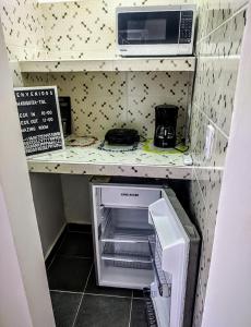 una pequeña cocina con microondas y nevera abierta en SAN SENDERISMO ROOM en Mariquita