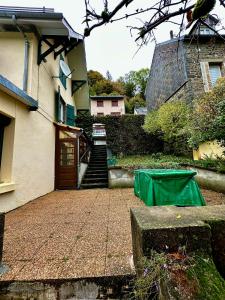 una escalera que conduce a una casa con una lona verde en Maison Le Barbier 10pers Le Mont Dore en Le Mont-Dore