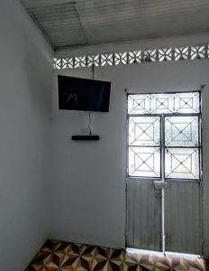 Habitación con puerta y TV en la pared en SAN SENDERISMO ROOM en Mariquita