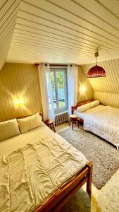 1 dormitorio con 2 camas y ventana en Maison Le Barbier 10pers Le Mont Dore en Le Mont-Dore