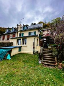 una casa grande con escaleras en un patio en Maison Le Barbier 10pers Le Mont Dore en Le Mont-Dore