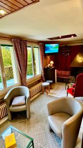 sala de estar con 2 sillas y TV en Maison Le Barbier 10pers Le Mont Dore en Le Mont-Dore
