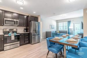 a kitchen and dining room with a table and blue chairs at Apartment at Vista Cay Resort in Orlando