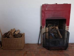 a room with a fireplace and a basket of wood at Cabane de douanier en baie du Mont Saint Michel hébergement insolite in Courtils +64 photos
