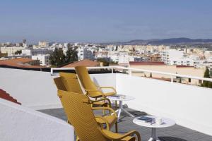 two chairs and a table on a balcony with a view at Alto House Faro AL de Assinatura Modernista in Faro