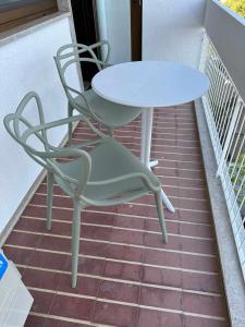 a white table and a chair on a balcony at Alto House Faro AL de Assinatura Modernista in Faro