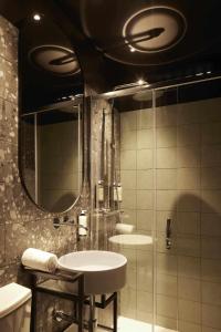 a bathroom with two sinks and a shower with a mirror at Alto House Faro AL de Assinatura Modernista in Faro