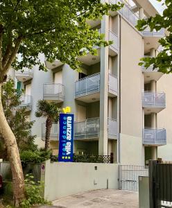 an apartment building with a sign in front of it at Residence Villa Azzurra in Rimini