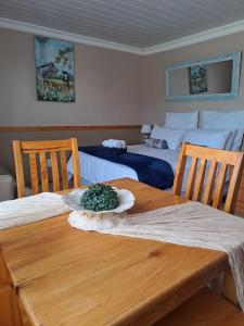 a wooden table with two beds in a room at Rus en Rose Gastehuis in Bloemfontein