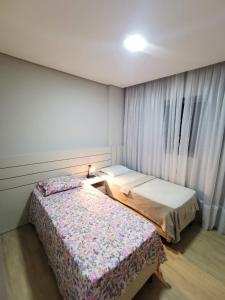 En eller flere senge i et værelse på Apartamento 3 Suítes - Itapema